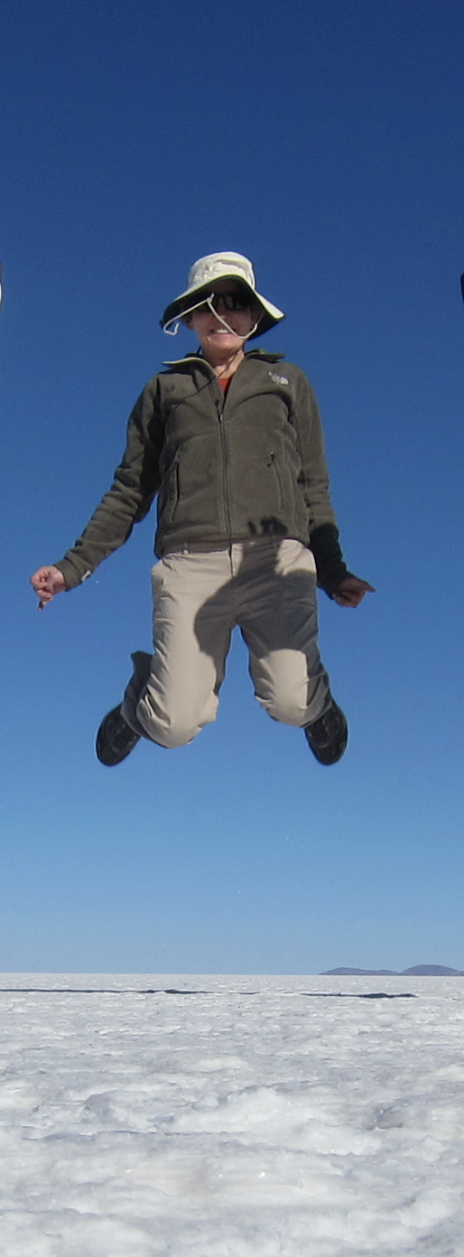 Diana jumping high above a white salt flat under a clear blue sky.