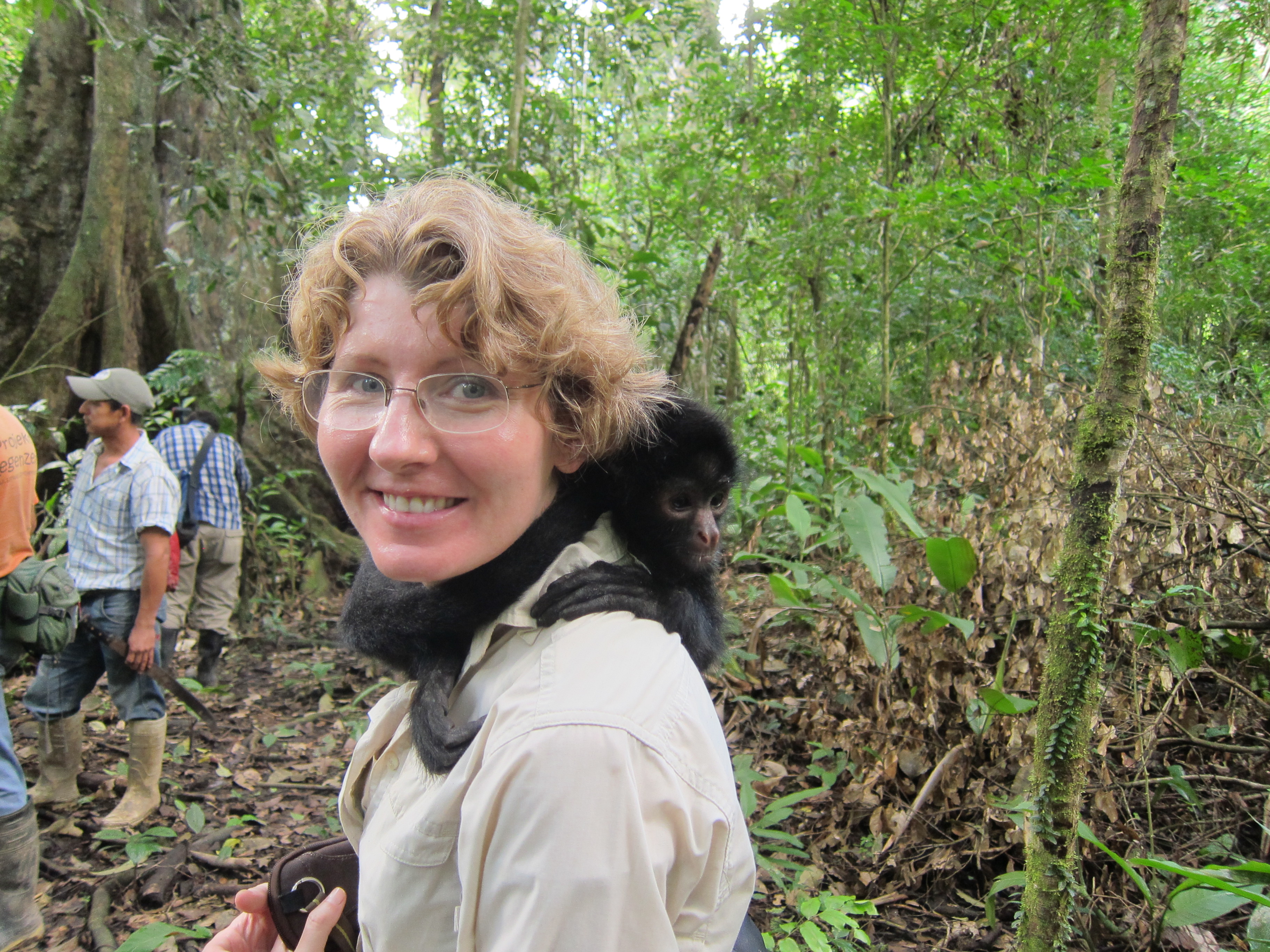 Diana in a Bolivian forest in 2012, with a small black monkey sitting on her shoulder.